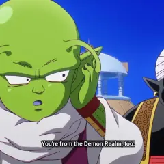 Zielony kosmita z antenkami i czarny Mr. Popo w turbanie rozmawiają.