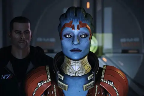 Mass Effect: Samara, asari z białymi oczami, stoi obok mężczyzny w czarnej bluzie z symbolem N7.