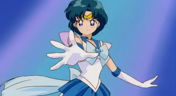Sailor Mercury wyciąga rękę, gotowa do walki. Jej niebieskie włosy i strój podkreślają jej moc.