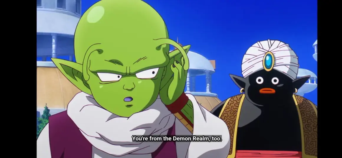 Zielony kosmita z antenkami i czarny Mr. Popo w turbanie rozmawiają.