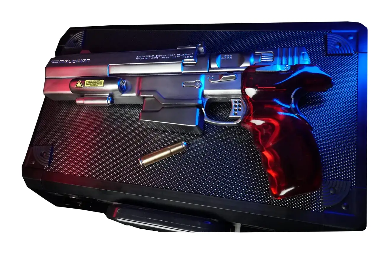 Pistolet Johnny'ego Silverhanda, z czerwonym, błyszczącym uchwytem, leży na czarnej walizce. Obok leży nabój.