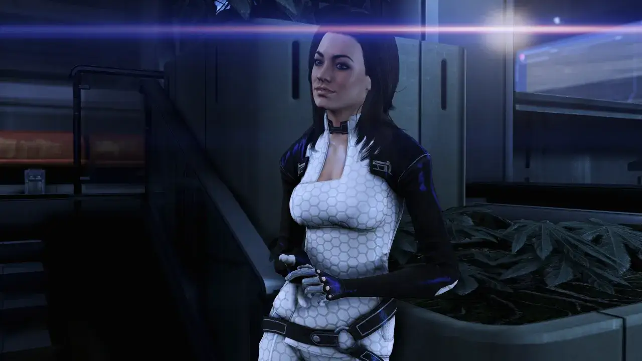 Miranda Lawson z Mass Effect 3 w białym kombinezonie z czarnymi akcentami, stoi w futurystycznym otoczeniu.
